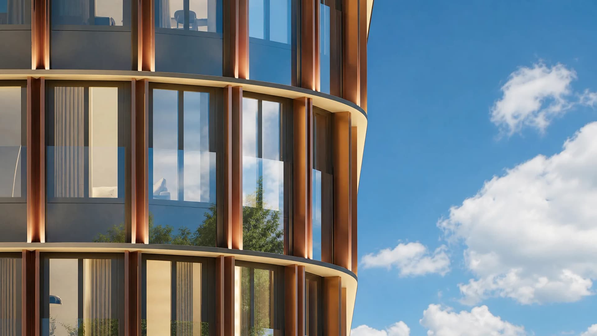Фасад Sky View крупным планом: скруглённые медные вертикали и панорамное остекление на фоне летнего неба